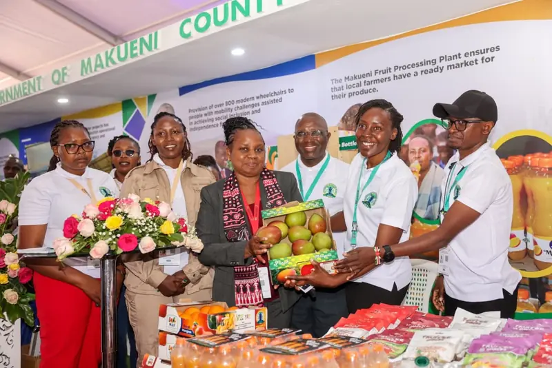Visitors sampling and presenting Makueni mango products at the 2025 Devolution Conference.